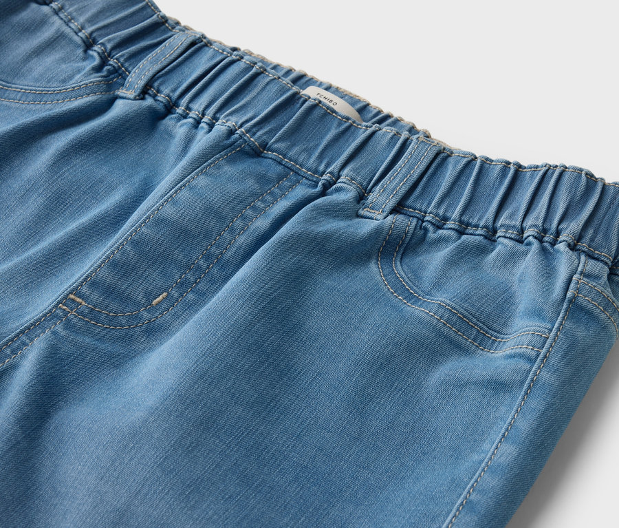 Gros plan d'un jean bleu clair avec une taille élastique.