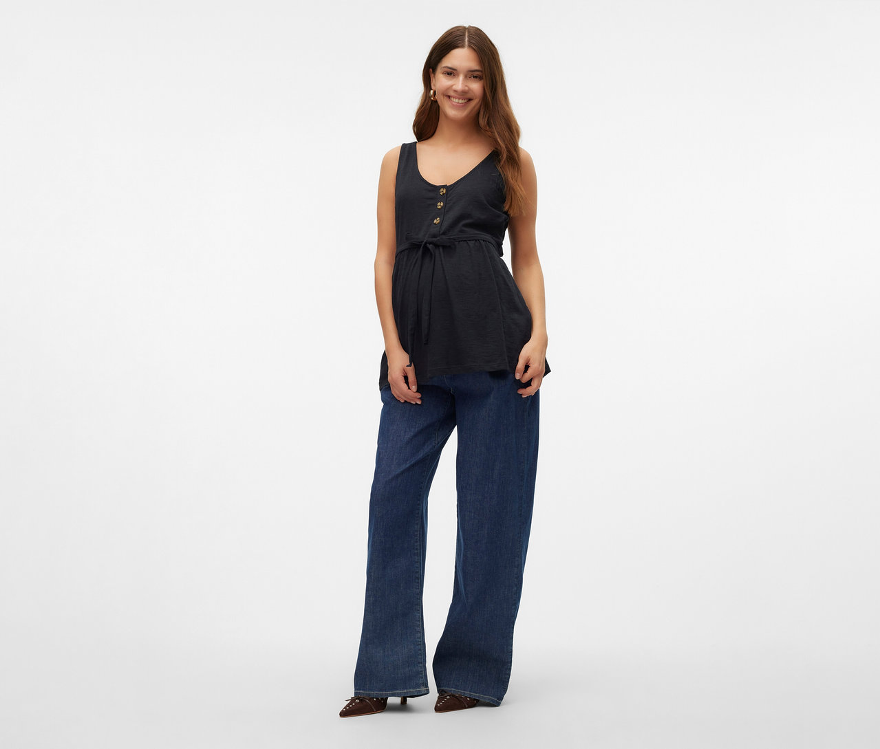 Une femme porte un top d’allaitement MAMALICIOUS «
MLEVI LIA
» avec un jean et des chaussures.