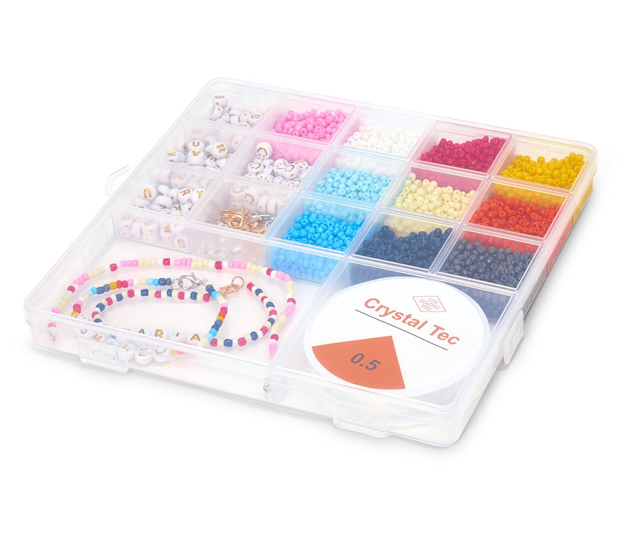 Une boîte transparente avec des perles colorées, des perles alphabet et un collier de perles colorées avec le nom ARIA.