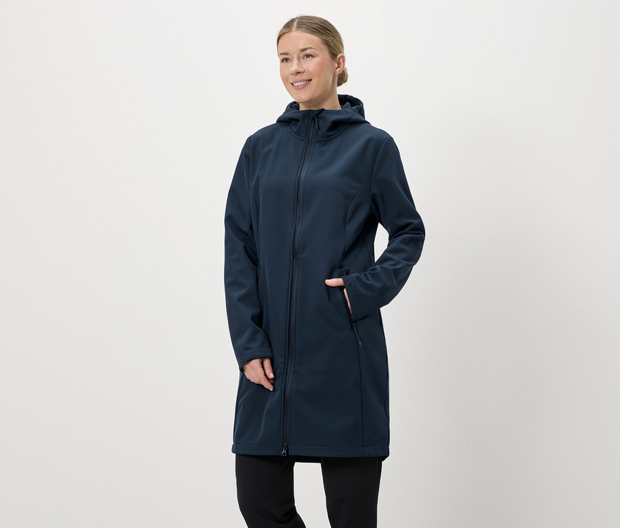 Femme portant un long manteau softshell bleu marine à capuche et fermeture éclair, la main dans la poche.
