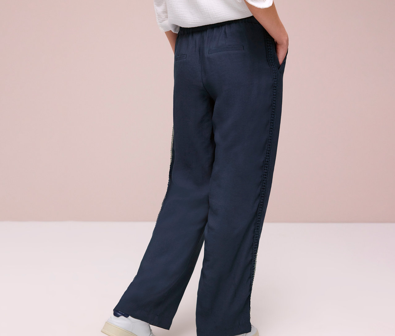 Personne vue de dos portant un pantalon Street One « Emee » et des baskets blanches.