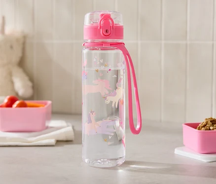 Une bouteille d'eau transparente avec des licornes est posée à côté de deux récipients roses sur un comptoir de cuisine.