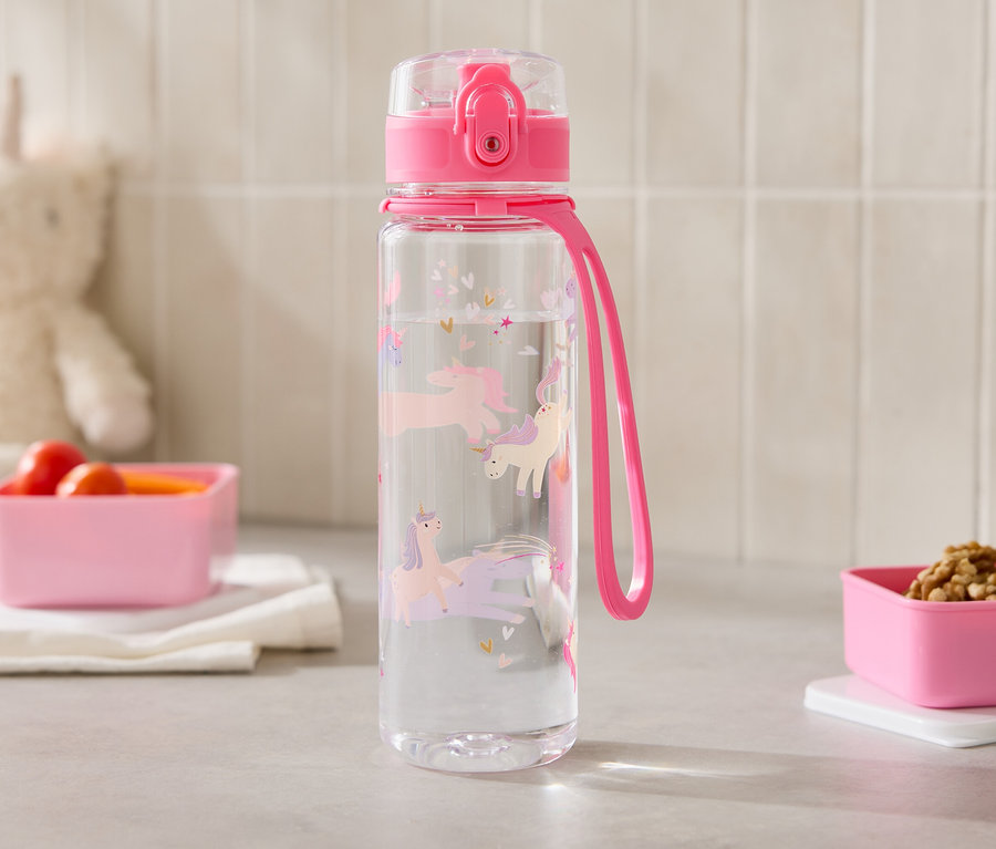 Une bouteille d'eau transparente avec des licornes est posée à côté de deux récipients roses sur un comptoir de cuisine.