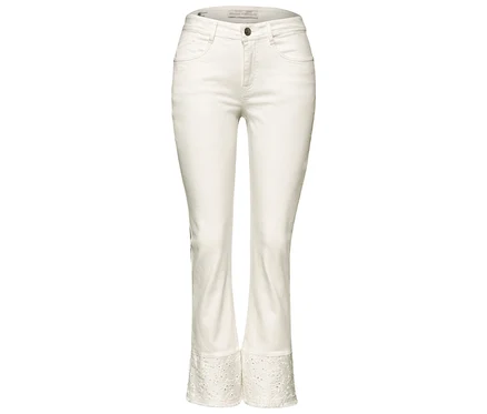 Jean Street One blanc avec une jambe courte, légèrement évasée et une broderie ajourée à l'ourlet.