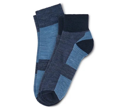 Deux chaussettes bleues sont posées l'une sur l'autre. Une chaussette est bleu clair et bleu foncé, l'autre bleu foncé et bleu clair.