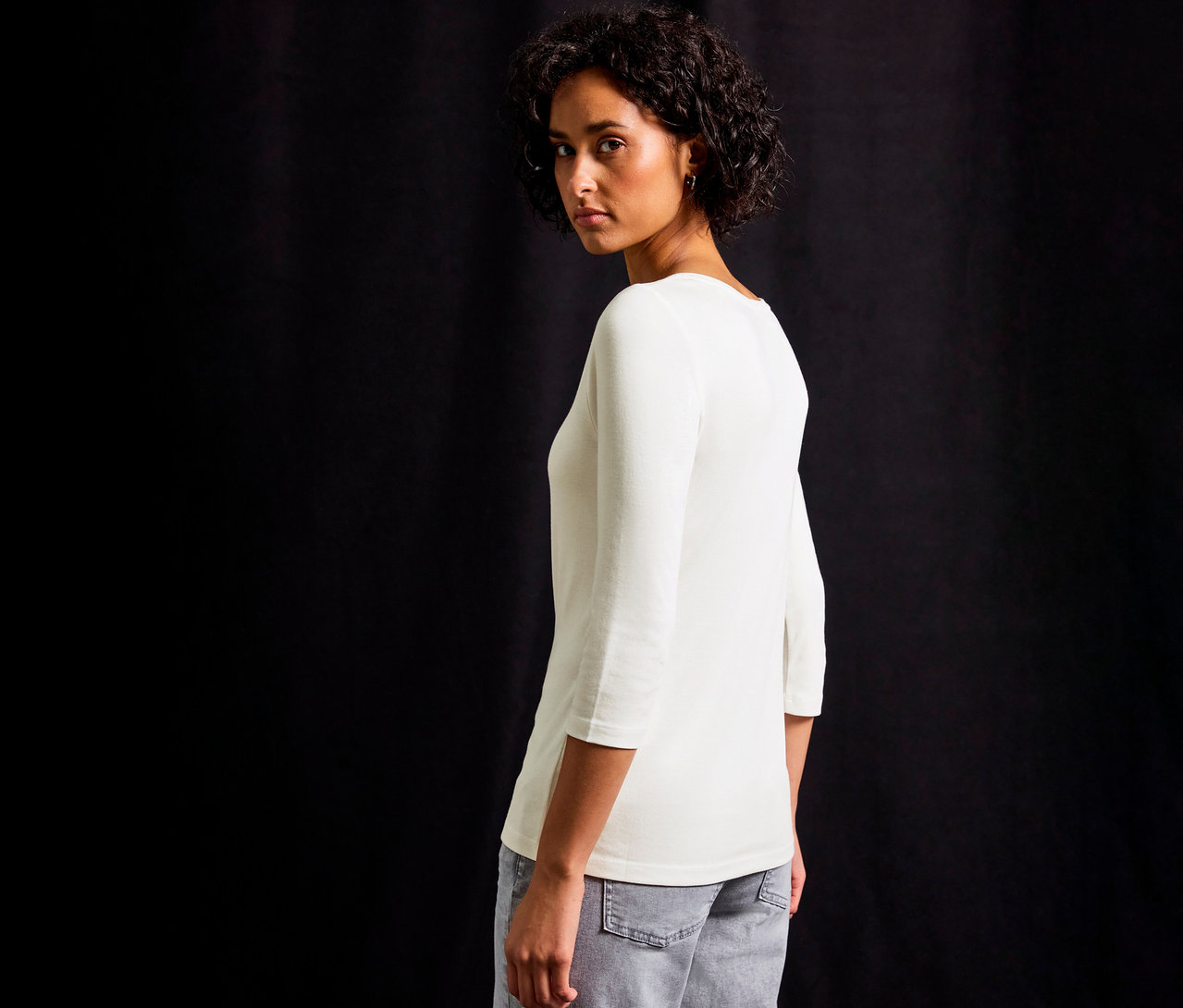 Femme regardant par-dessus son épaule portant un maillot 3/4 avec détail bouton Street One, blanc.