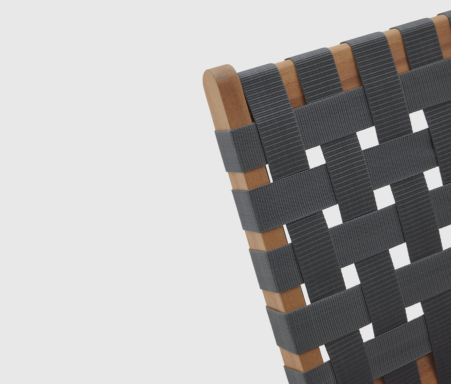 Gros plan d'une chaise avec un cadre en bois et une assise tissée grise.