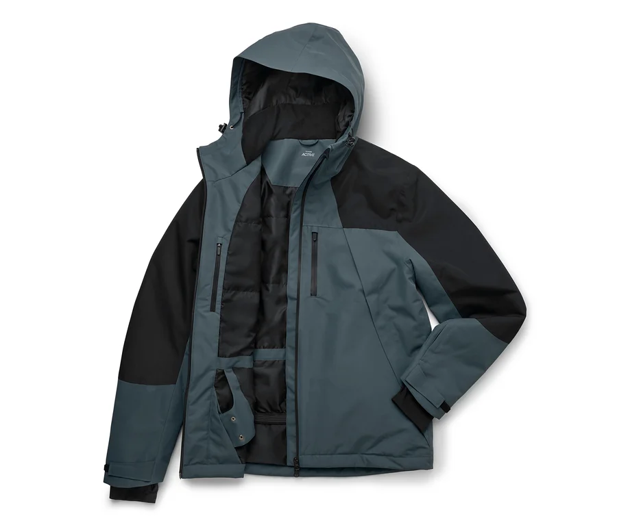 Une veste homme bicolore en bleu ardoise et noir, posée à plat avec le devant ouvert. La veste a une capuche, des épaules et des manches noires, et un corps bleu ardoise. Le devant ouvert révèle une doublure intérieure matelassée noire et plusieurs poches intérieures zippées.