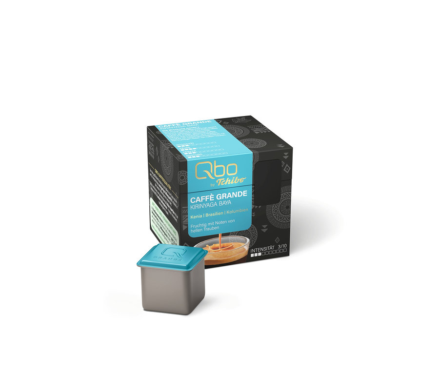 Une boîte grise avec une bande bleue et l'inscription blanche Qbo by Tchibo Caffè Grande Kirinyaga Baya, à côté d'une capsule de café grise avec un couvercle bleu. La boîte indique l'origine (Kenya, Brésil, Colombie), des notes fruitées de raisins clairs et une intensité de 3/10.