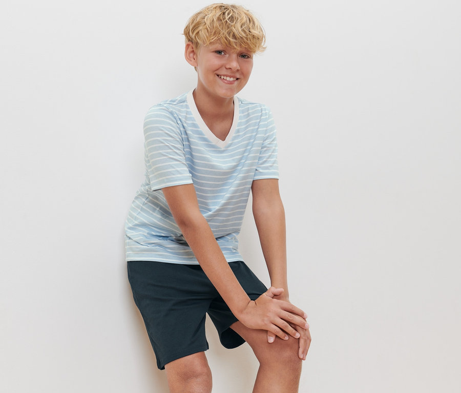 Un garçon pose en pyjashort pour enfant.