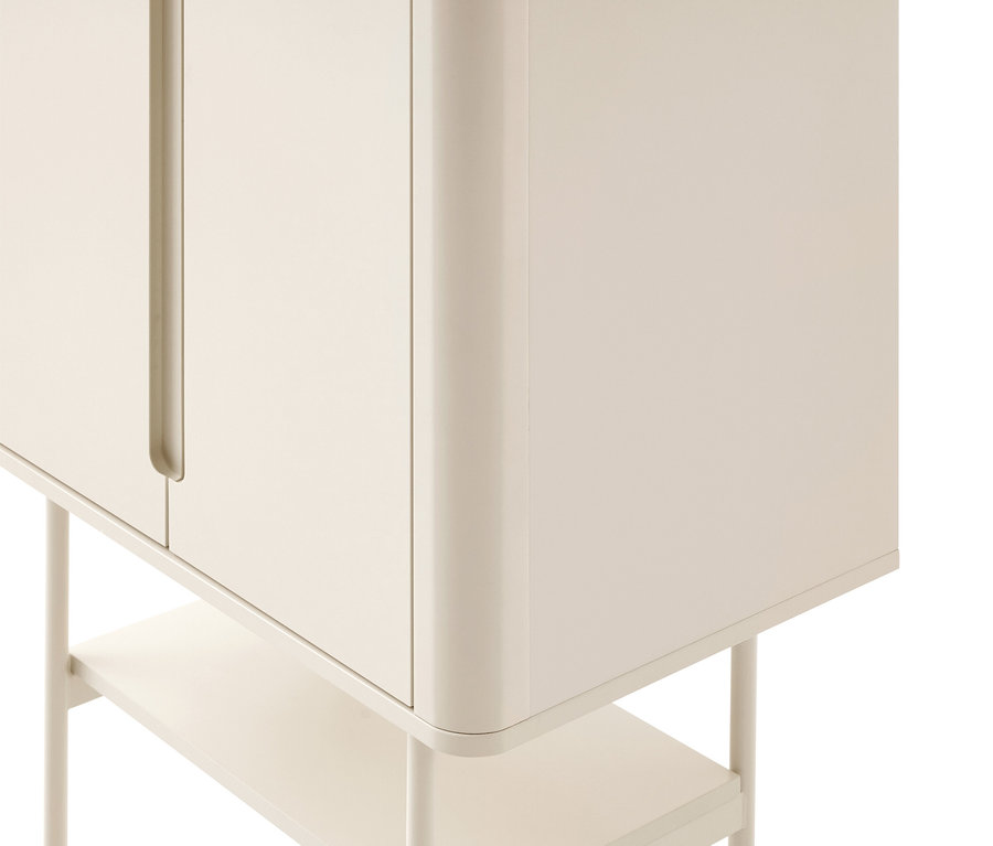 Commode beige aux coins arrondis, avec deux portes à poignées intégrées et une étagère inférieure sur de fines pattes.