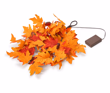 Un amas de feuilles d'automne artificielles orange et rouges, avec un fil noir menant à un boîtier de piles rectangulaire marron.
