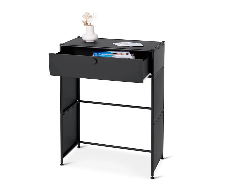 Une console en métal noire « CN3 » avec un tiroir est visible. Un vase avec des fleurs se trouve sur le dessus de la console.