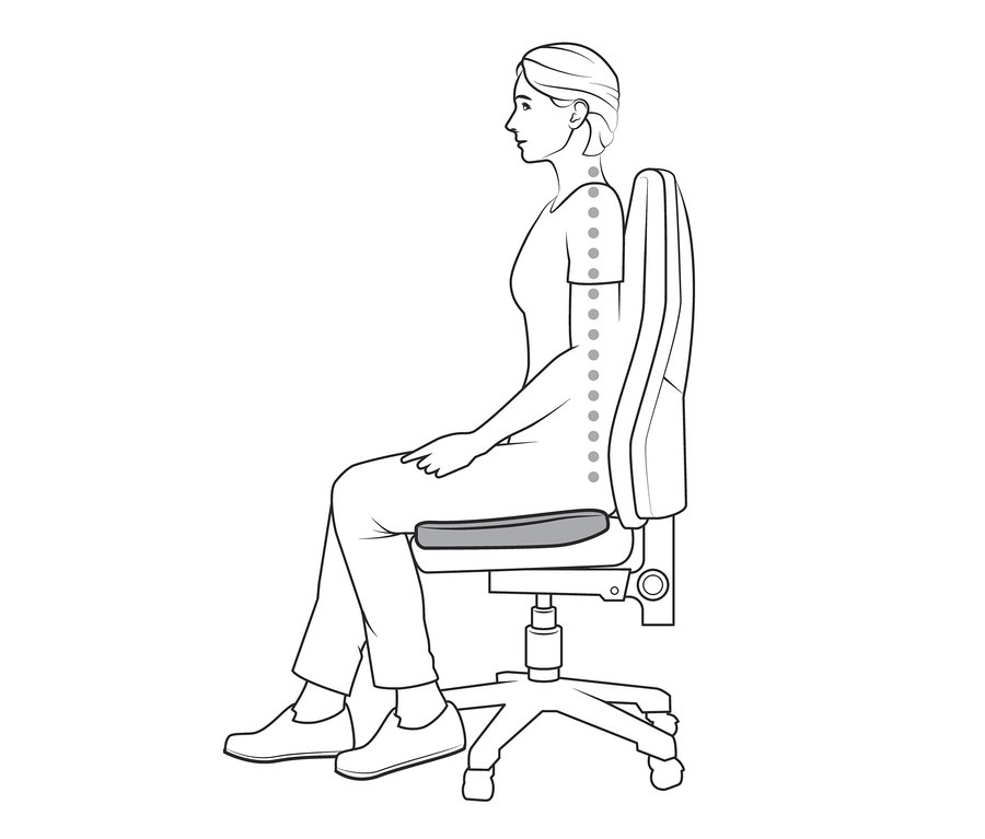Femme assise sur une chaise avec un coussin d’assise avec mousse en mémoire de forme.
