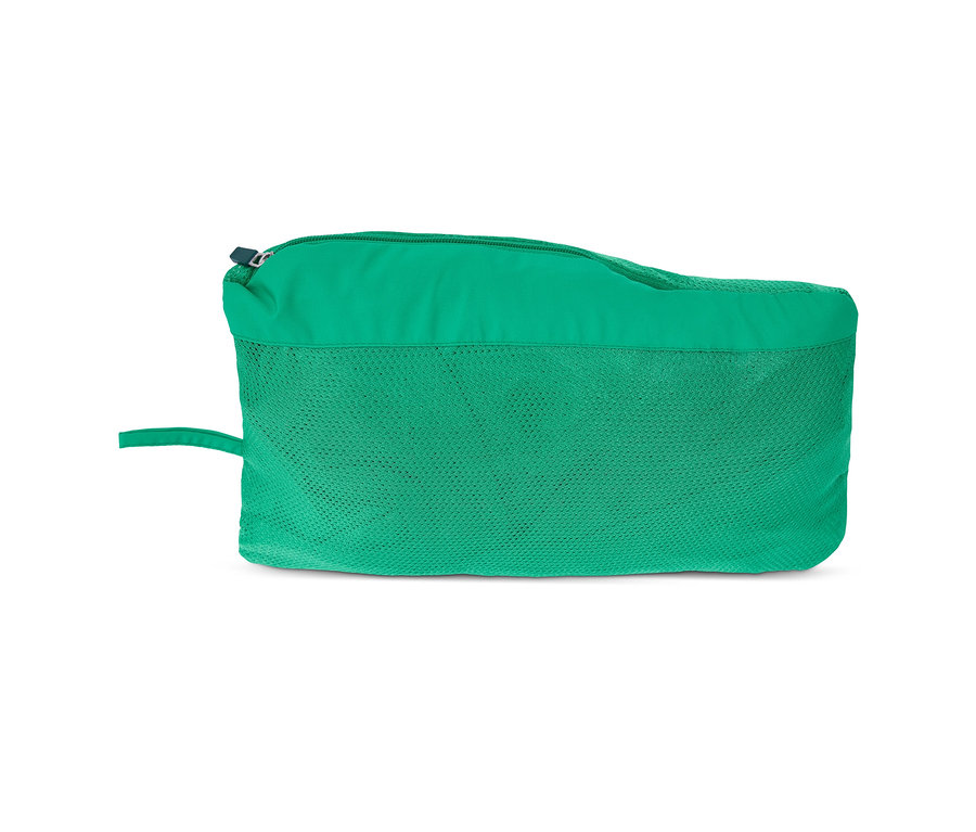 Une veste fonctionnelle coupe-vent verte pliée dans un sac.