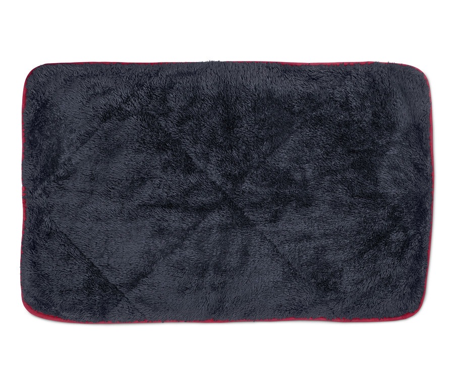 Une couverture moelleuse pour chien avec une bordure rouge.