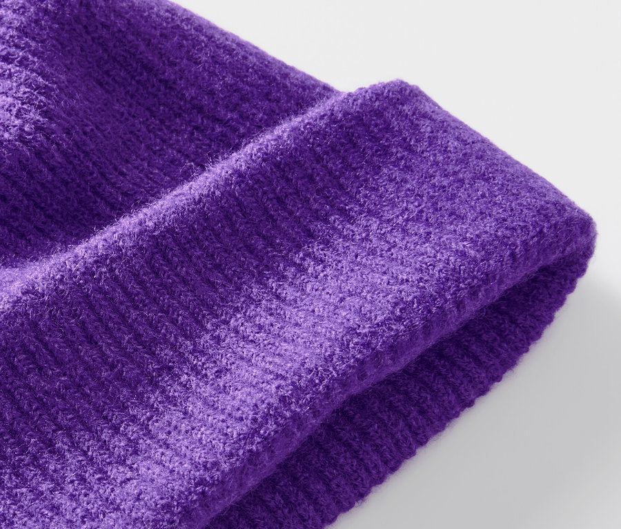 Gros plan d'un bonnet en maille violet.