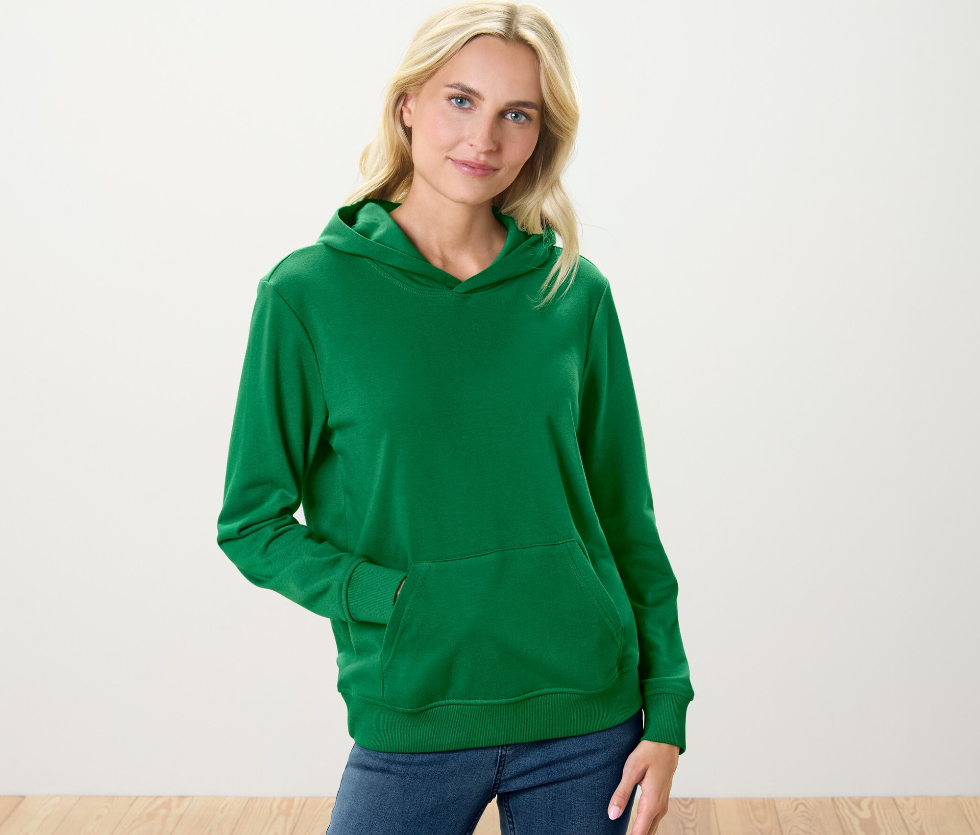Femme portant un sweat à capuche vert.