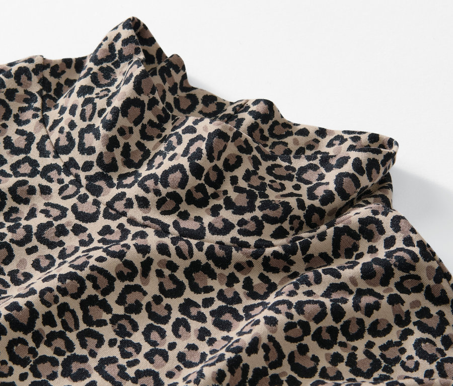 Gros plan sur une blouse imprimée à col montant avec un motif léopard.