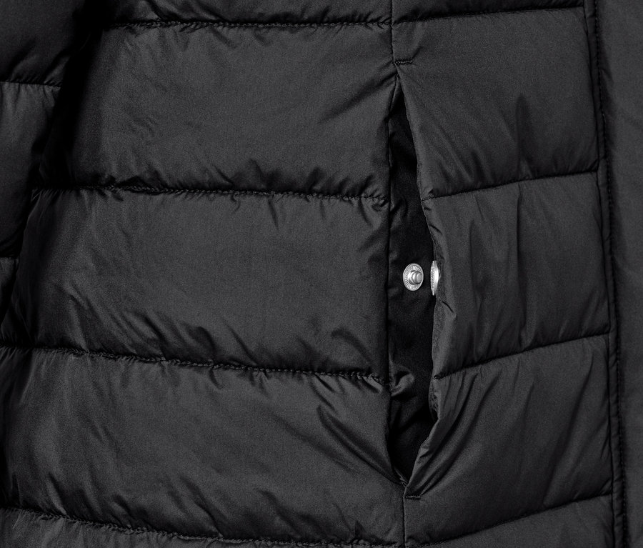Détail d'un manteau matelassé noir avec une poche.