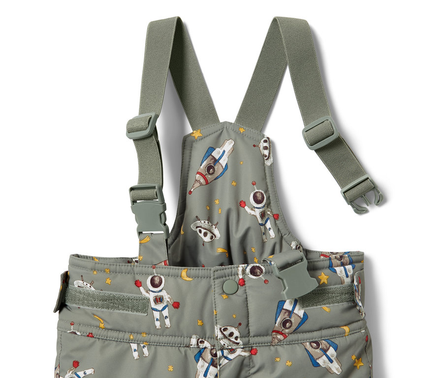Détail d'une combinaison de ski pour enfant avec des motifs d'astronautes, de fusées et d'étoiles.