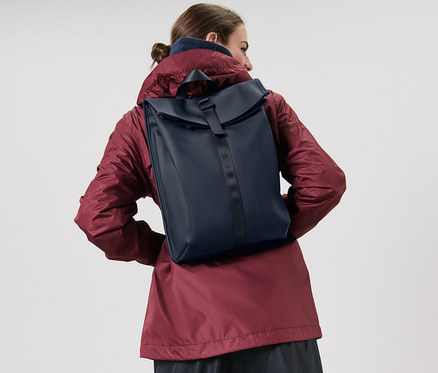 Femme portant un sac à dos de pluie.