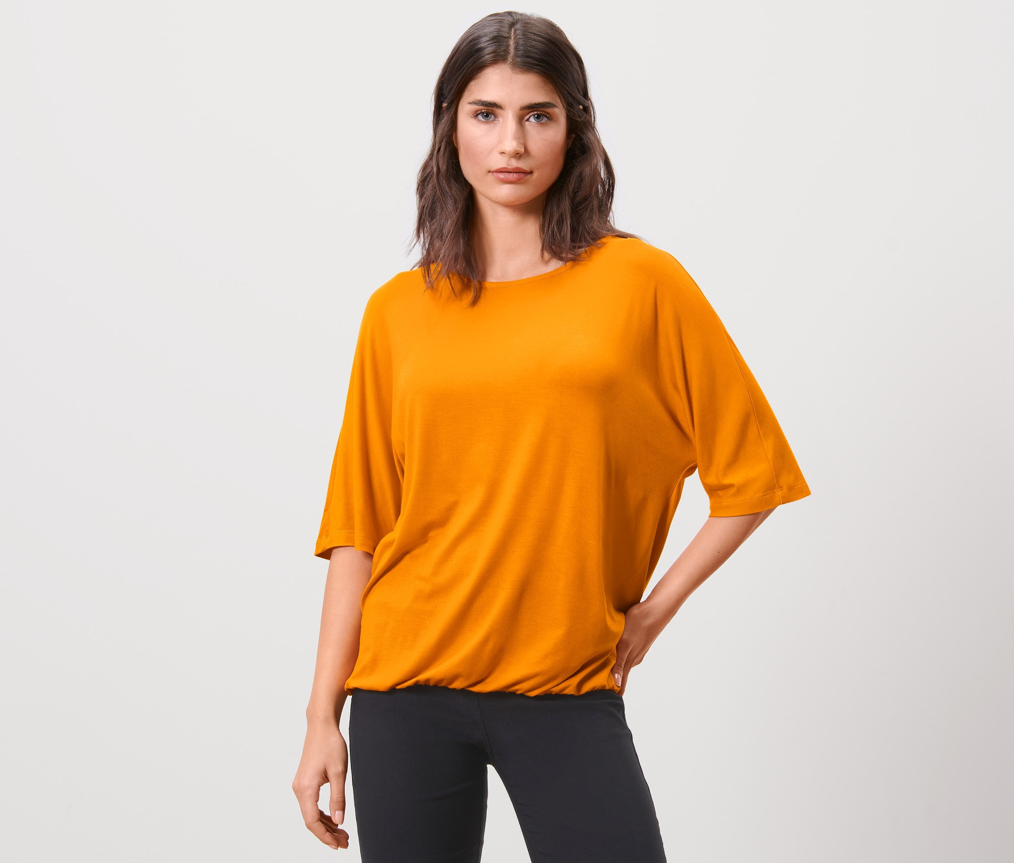 Femme posant dans une blouse orange.