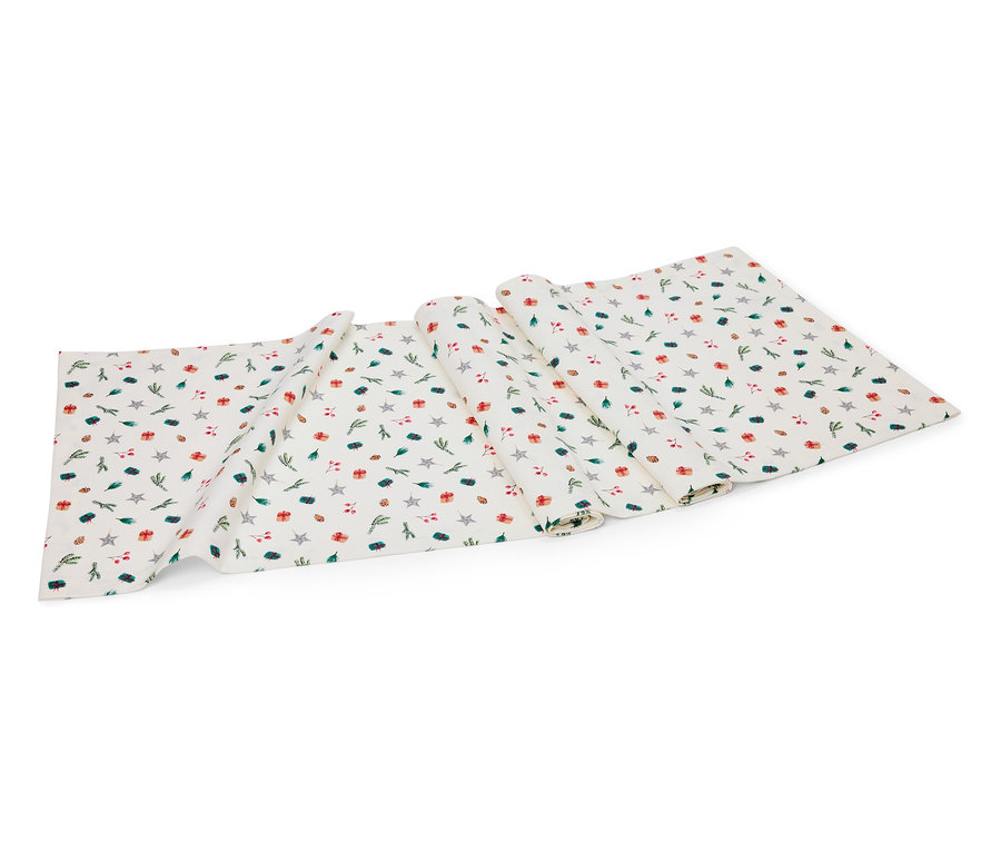 Chemin de table blanc avec motif d'étoiles, de cadeaux et de brindilles.