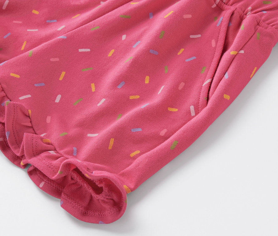 Gros plan d'un short de survêtement pour enfants avec des vermicelles colorés et des froufrous.