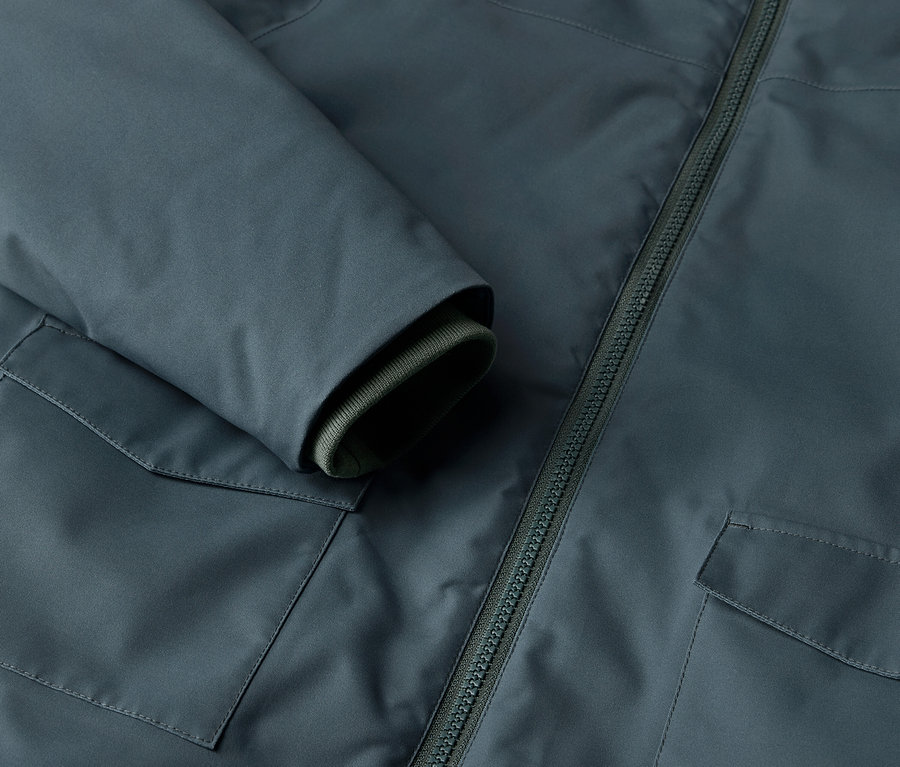 Détail d'une parka d'hiver pour enfants avec poche et fermeture éclair.
