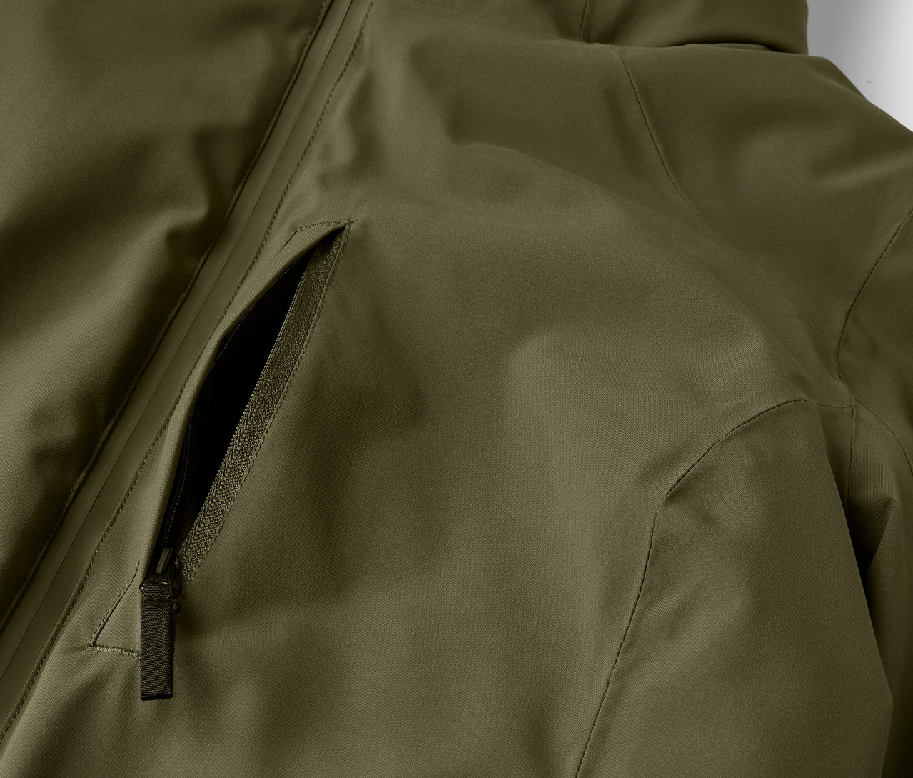 Détail d'une veste vert olive avec une poche zippée.