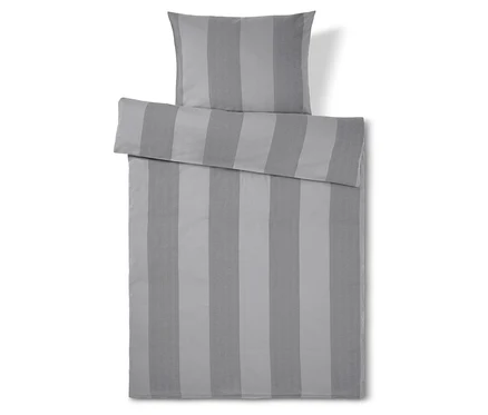 Linge de lit rayé gris avec oreiller sur le dessus.