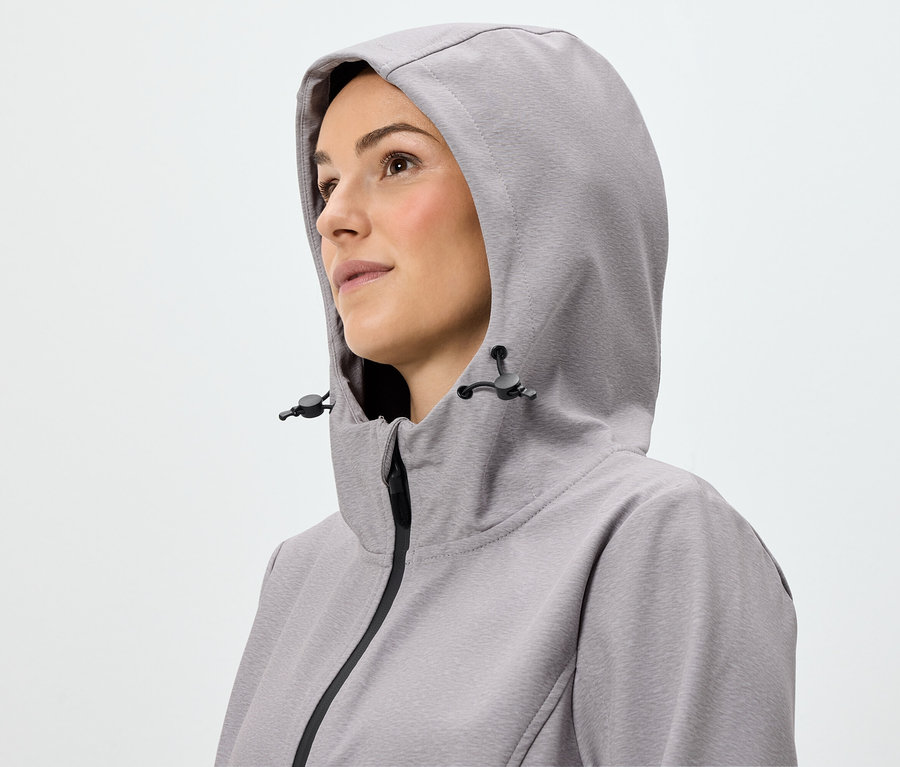 Portrait d'une femme portant une veste zippée à capuche violet clair.