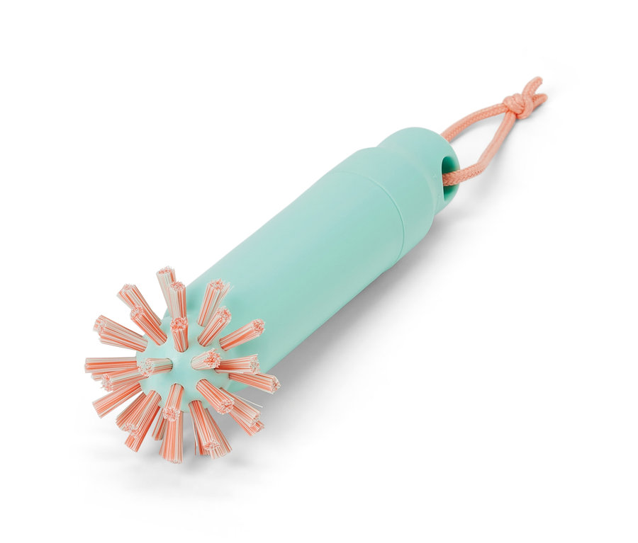 Une brosse de vidange 2 en 1 avec un manche vert d'eau et des poils roses.