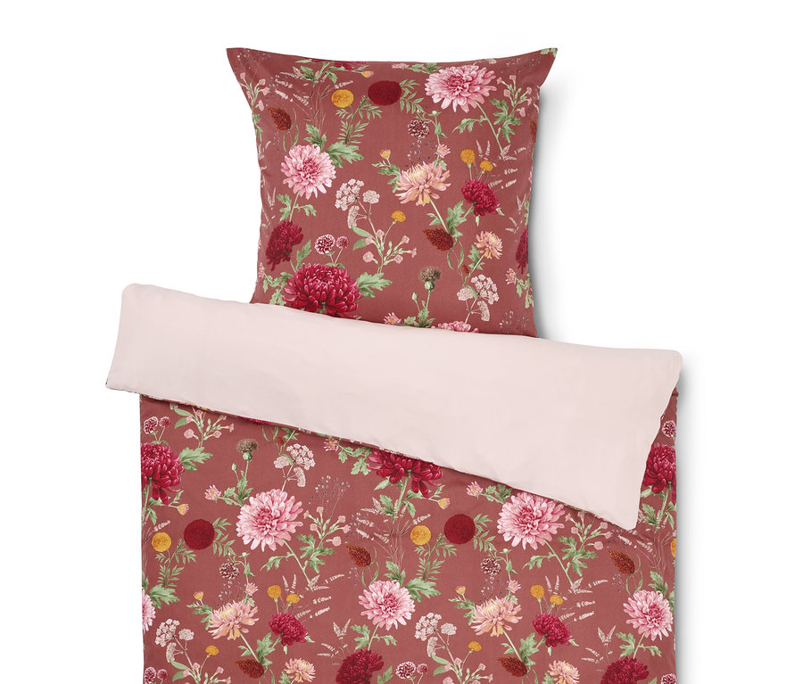 Linge de lit à motif floral avec un oreiller sur le dessus.