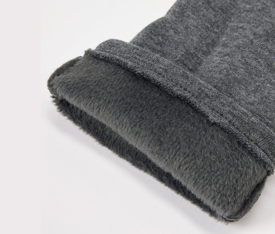 Gros plan d'un tissu gris avec une doublure en polaire.
