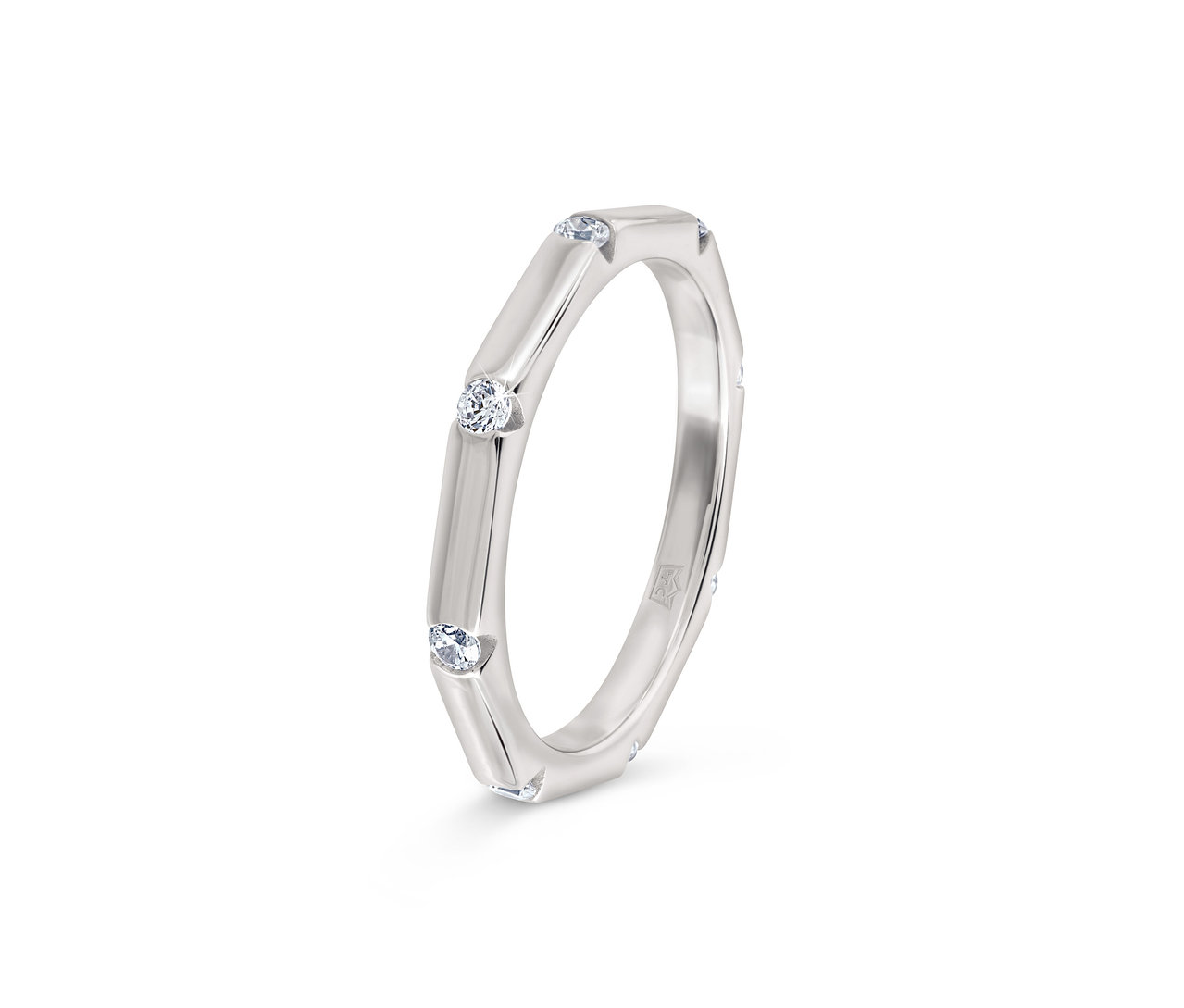 Bague argentée avec trois pierres claires serties.