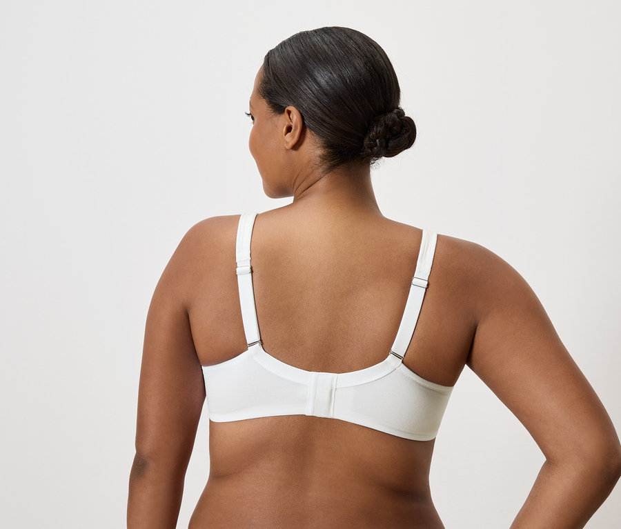 Vue arrière d'une femme aux cheveux relevés portant un soutien-gorge blanc.