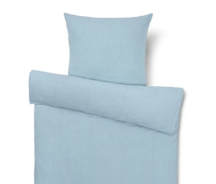 Linge de lit bleu clair avec oreiller, couette et traversin.