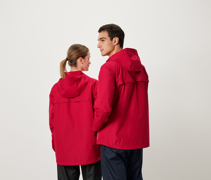 Un homme et une femme se tiennent dos à dos et portent des vestes rouges à capuche.