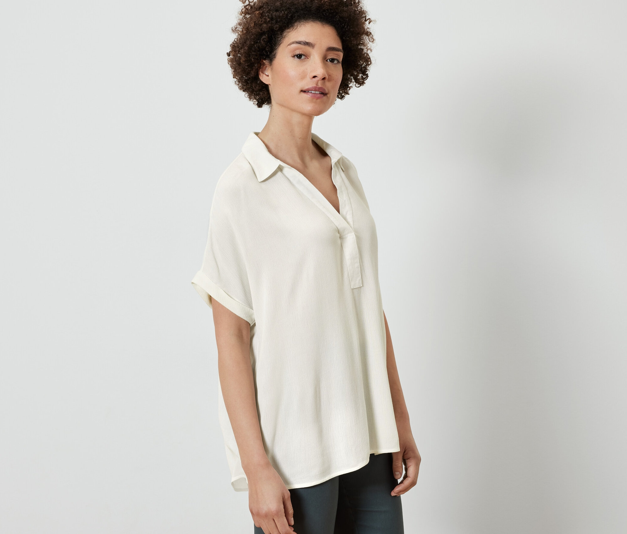 Femme posant en blouse crème.