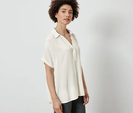 Femme posant en blouse crème.
