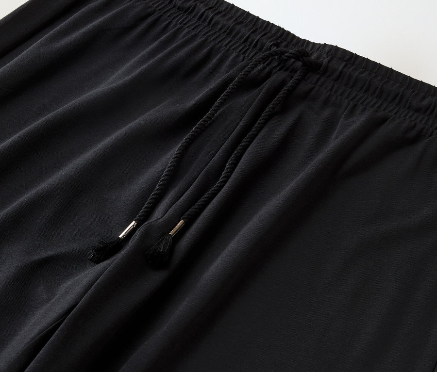 Gros plan d'un pantalon noir avec cordon de serrage.