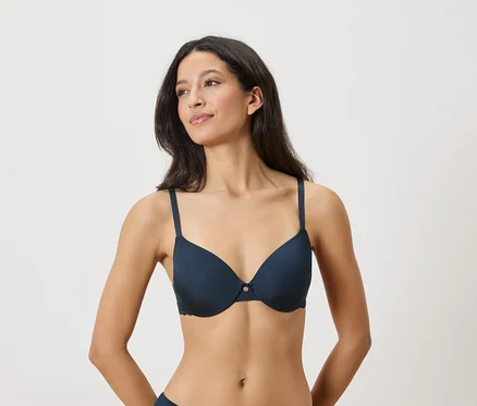 Femme portant un soutien-gorge bleu marine à armatures avec des détails délicats.