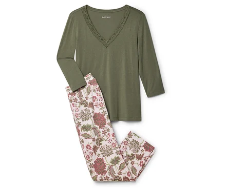 Un haut vert à manches longues avec des détails en dentelle et un pantalon de pyjama à fleurs sont posés sur un fond blanc.