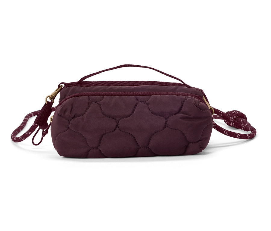 Gros plan d'un sac à main matelassé couleur aubergine avec une poignée et une bandoulière en corde sur fond blanc.
