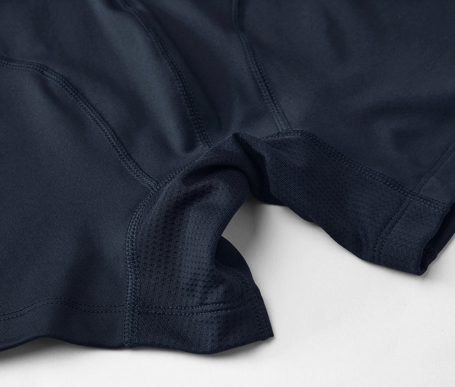 Gros plan de sous-vêtements de sport bleu marine avec des empiècements en maille et des coutures sur un fond clair.