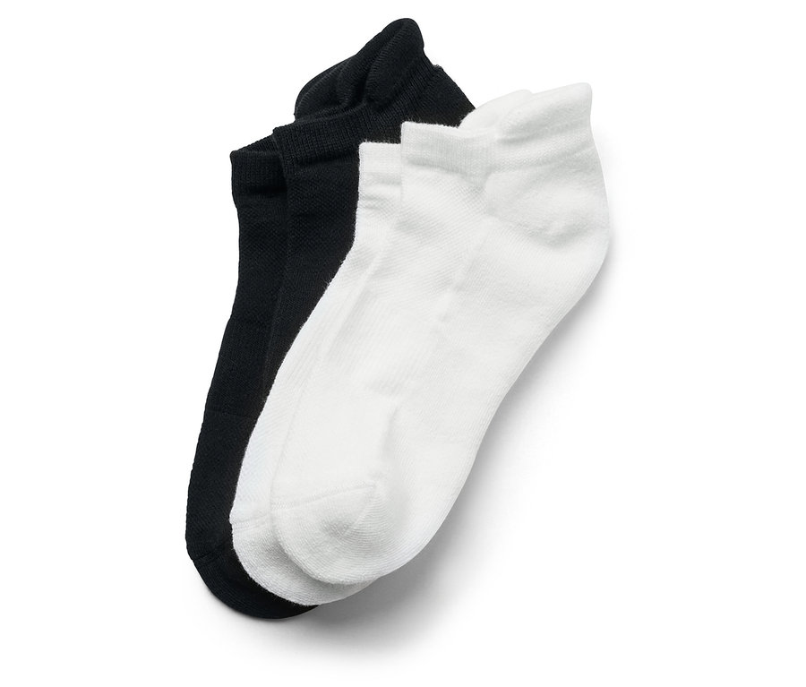 Gros plan d'une paire de chaussettes noires et d'une paire de chaussettes blanches.
