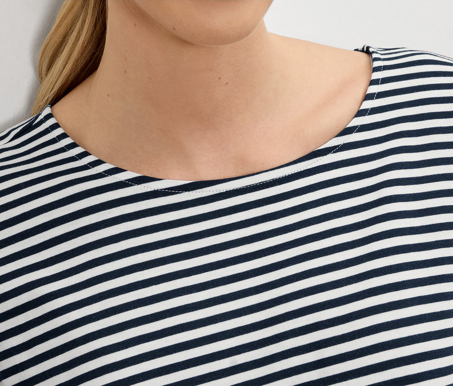 Gros plan d'une femme portant un haut rayé bleu et blanc.