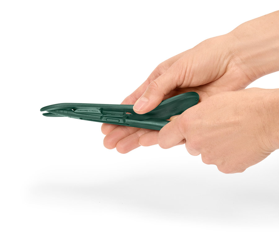 Les mains tiennent une pince en plastique verte.